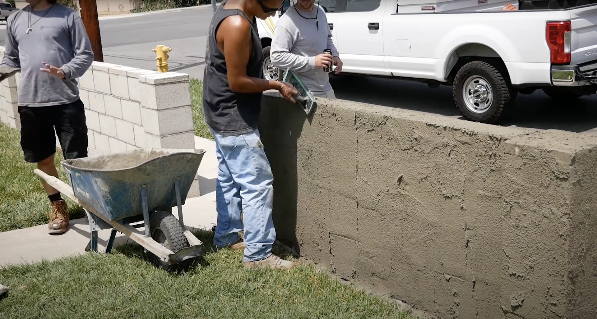 Concrete contractor team working on residential driveway installation with professional equipment