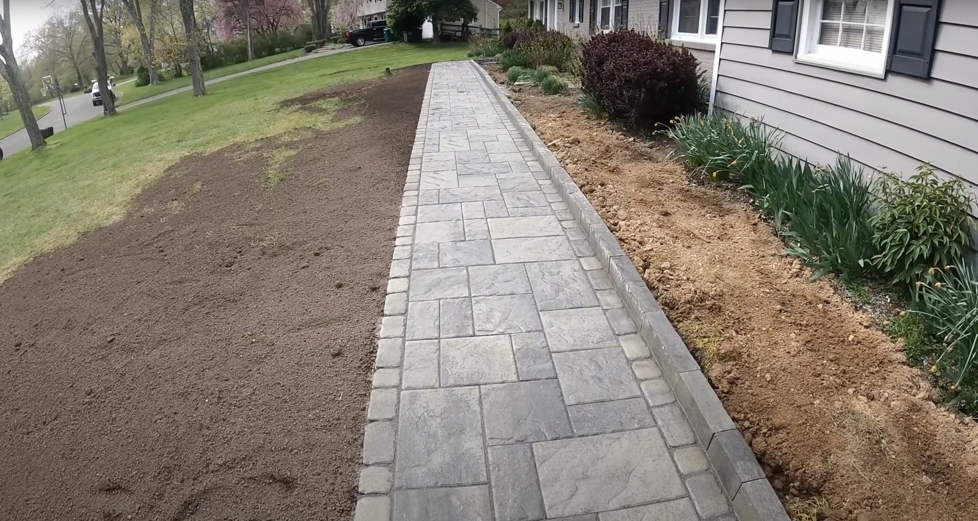 Beautiful stamped concrete walkway with decorative border and professional landscaping